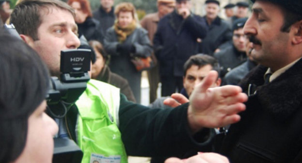 Репортер и полиция на митинге обманутых дольщиков перед зданием
 администрации президента Азербайджана. Баку, 18 января 2012 г. Фото:
www.irfs.az