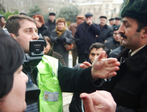 Репортер и полиция на митинге обманутых дольщиков перед зданием
 администрации президента Азербайджана. Баку, 18 января 2012 г. Фото:
www.irfs.az