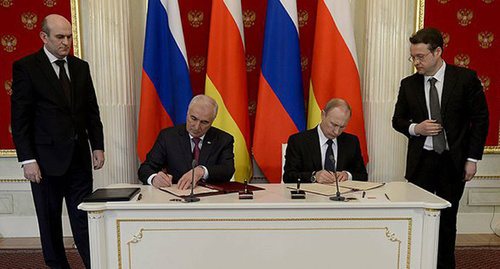 Vladimir Putin (right) and Leonid Tibilov (left) signing Russian-South-Ossetian alliance and integration treaty.