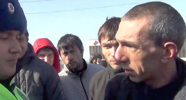 Andzor Akhokhov talking to law enforcer durign the action against the Sochi Olympic Games. Screenshot from video "NO SOCHI. Cherkessia. Kabarda. 07.02.14" posted on YouTube by Cherkes Cherkesia, https://www.youtube.com/watch?v=SiVpnRFrurc&feature=youtu.be Andzor Akhokhov talking to law enforcer durign the action against the Sochi Olympic Games. Screenshot from video "NO SOCHI. Cherkessia. Kabarda. 07.02.14" posted on YouTube by Cherkes Cherkesia, https://www.youtube.com/watch?v=SiVpnRFrurc&feature=youtu.be