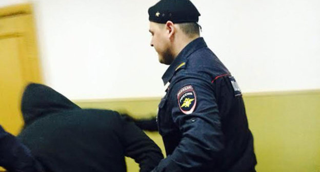 Law enforcer escorting defendant in Boris Nemtsov murder case. Basmanny District Court of Moscow, April 6, 2015. 