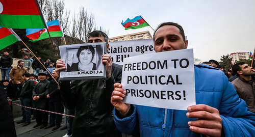 A participant of the protest action holds a poster with a portrait of a political prisoner Khadija Ismayilova and a poster 'Freedom to political prisoners!'. Baku, March 15, 2015. Photo by Aziz Karimov for the "Caucasian Knot"