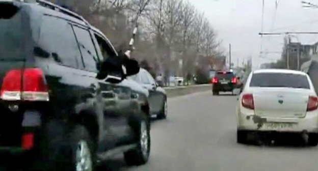 The security guard from the jeep of the convoy of the head of the republic Ramazan Abdulatipov beating the side mirrors of the surrounding cars with a police truncheon. Makhachkala, April 1, 2015. Screenshot of a video  by the user MishkaKG http://www.youtube.com/watch?v=GZzEzujUah8