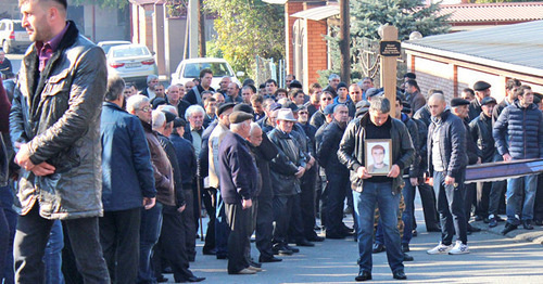 The participant of the funeral procession with Vladimir Tskaev's portrait. Photo by Emma Marzoeva for the "Caucasian Knot"