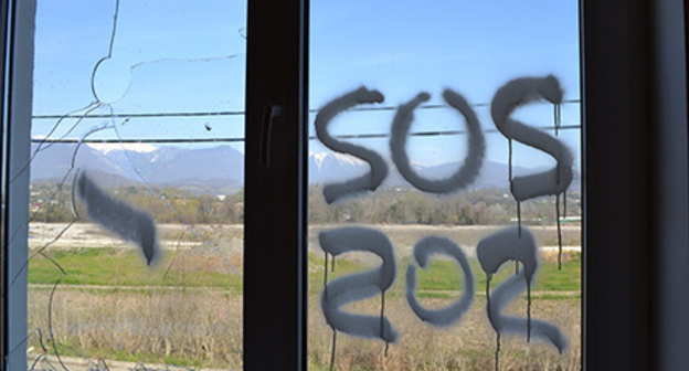 Inscription ‘SOS’ on the window of dilapidated house of cottage settlement for Olympic resettlers, Vesyoloe-Psou neighbourhood, Adler District of Sochi. Photo by Svetlana Kravchenko for the ‘Caucasian Knot’. Inscription ‘SOS’ on the window of dilapidated house of cottage settlement for Olympic resettlers, Vesyoloe-Psou neighbourhood, Adler District of Sochi. Photo by Svetlana Kravchenko for the ‘Caucasian Knot’.