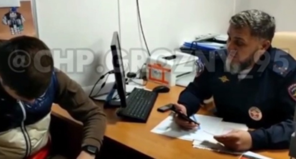 A police officer reprimands the detainee. Screenshot of the video posted on the "ChP/Grozny" Telegram channel https://t.me/chpgrozny95/2334 A police officer reprimands the detainee. Screenshot of the video posted on the "ChP/Grozny" Telegram channel https://t.me/chpgrozny95/2334