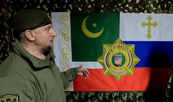 Apti Alaudinov is standing against the background of the “Akhmat” special forces flag. A screenshot from a video posted on the Anastasia Babir’s Telegram channel on May 23, 2025, https://t.me/SovaBabir/217.
Apti Alaudinov is standing against the background of the “Akhmat” special forces flag. A screenshot from a video posted on the Anastasia Babir’s Telegram channel on May 23, 2025, https://t.me/SovaBabir/217.