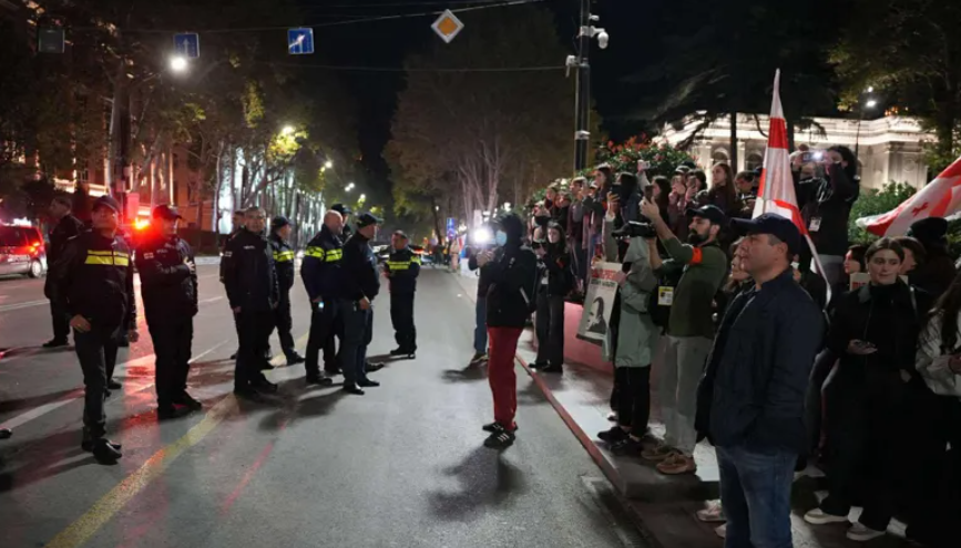 Security forces and protesters on Rustaveli Avenue. Screenshot from Interpressnews photo from October 25, 2025, https://www.interpressnews.ge/ka/article/852879-rustavelis-gamzirze-saavtomobilo-mozraoba-agdga