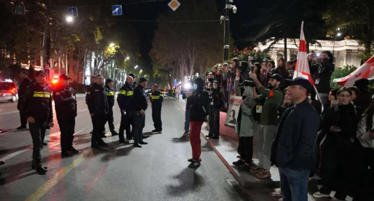 Security forces and protesters on Rustaveli Avenue. Screenshot from Interpressnews photo from October 25, 2025, https://www.interpressnews.ge/ka/article/852879-rustavelis-gamzirze-saavtomobilo-mozraoba-agdga