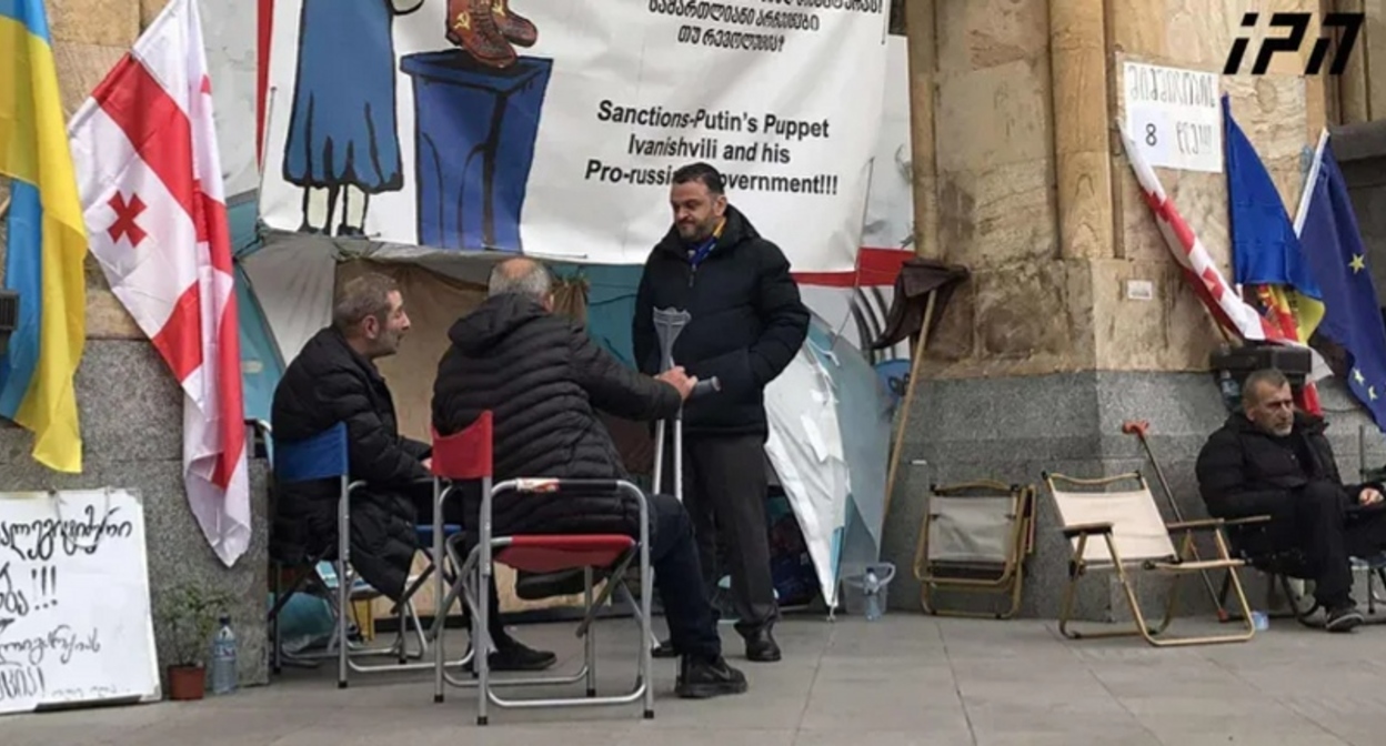 Hunger strikers outside the Georgian parliament. Photo: Interpressnews https://www.interpressnews.ge/ru/article/171616-gedevan-popkhadze-8-i-den-golodovki-k-nam-prisoedinilis-2-cheloveka-i-na-dannyi-moment-golodaiut-8-chelovek-my-bodry-i-schitaem-chto-eta-aktsiia-dolzhna-rasshiritsia-poka-ne-izmenitsia-politicheskaia-obstanovka-v-strane