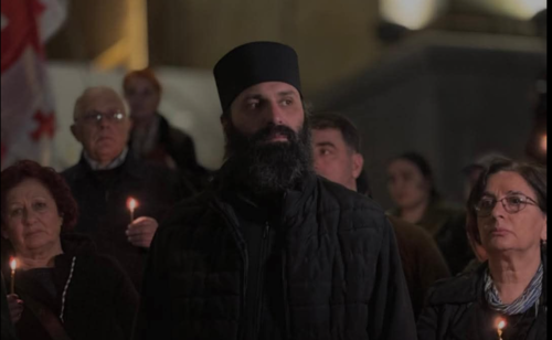 Still of Father Ilia Toloraya at a rally in Tbilisi. Photo: TV Pirveli / https://tvpirveli.ge/ka/siaxleebi/sazogadoeba/119492-shetskaleba-ki-ara-tsesit-bodishi-unda-moukhadon-sindisis-patimrebs-mama-ilia