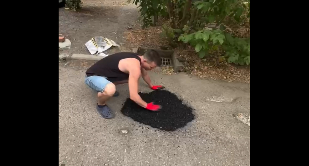 A resident of Krasnodar repairs the roadway in the courtyard. Frame from the video https://t.me/tipichkras/82566 A resident of Krasnodar repairs the roadway in the courtyard. Frame from the video https://t.me/tipichkras/82566